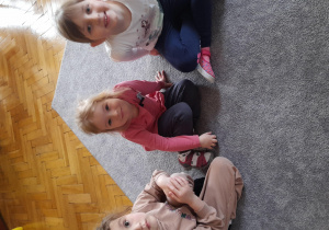 Dziewczynki siedzą na dywanie