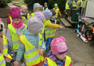 Dzieci wychodzą z przedszkola ubrane w odblaskowe kamizeli