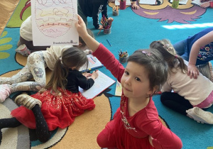 Dziewczynka prezentuje samodzielnie pokolorowane pisankę