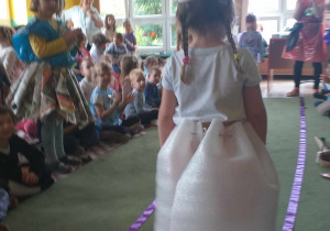 dziewczynka prezentuje strój przechodząc po dywanie