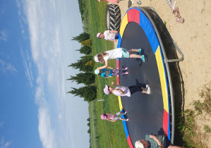 dzieci skacza na trampolinie