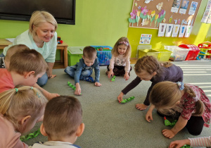 Dzieci siedzą w kole i naśladują ruchy i syczenie węża