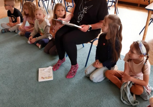 Dzieci słuchają książki czytanej przez panią