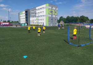 Dzieci rozgrzewają się na boisku przed meczem.