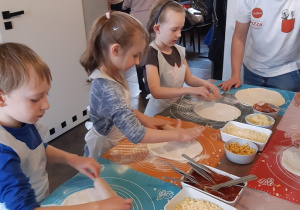 Dzieci wałkują ciasto na pizzę