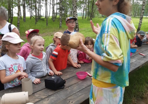 Dzieci słuchają instrukcji wykonania stworka z trocin i ziaren trawy