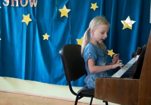 Dziewczynka śpiewa i gra na pianinie