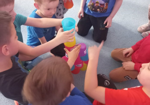 Dzieci układają wieżę z kubeczków symbolizującą ekosystem