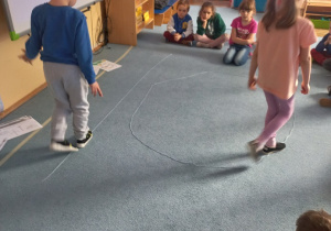 Dzieci chodzą po sznurkach symbolizujących energię odnawialną i nieodnawialną