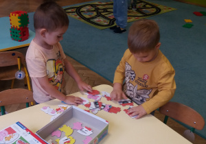 chłopcy układają puzzle