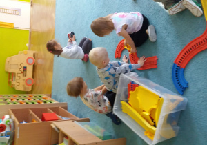 dzieci budują tor z plastikowych klocków