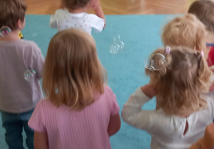 Pani puszcza dzieciom bańki mydlane