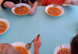 Dzieci na obiad jedzą zupę dyniową