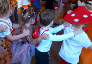 Dzieci stoją jedno za drugim trzymając się za ramiona