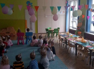 Dzieci siedzą w kole i czekają na świetną zabawę