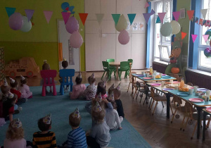 Dzieci siedzą w kole i czekają na świetną zabawę