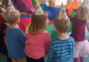 Dzieci trzymają chustę animacyjną i bawią się wspólnie ze swoją Panią