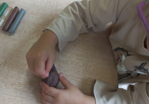 Dziewczynka robi jeżyka z plasteliny