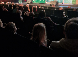 Dzieci siedzą na widowni i oglądają przedstawienie