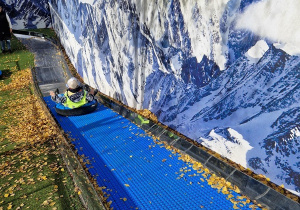 Chłopiec zjeżdża na pontonie ze skoczni narciarskiej