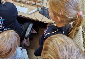 Dzieci oglądają sposób malowania bombek