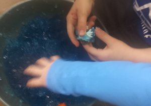 Dzieci szukają przedmiotów w niebieskiej galaretce