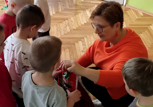 Nauczycielka wręcza dziecku paczkę