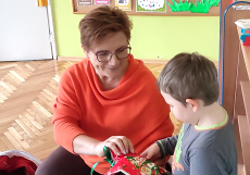 Nauczycielka wręcza paczkę chłopcu