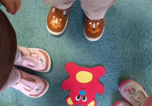 Dzieci podczas zabawy ruchowej odnalazły na dywanie czerwonego misia