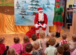 Dzieci siedzą i rozmawiają z Mikołajem 
