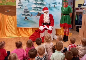 Dzieci siedzą i rozmawiają z Mikołajem