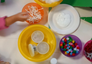 Dzieci przyklejają na choinkę kawałki zielonego papieru