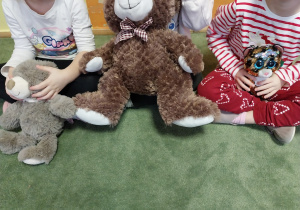 Misie siedzą w kole razem z dziećmi