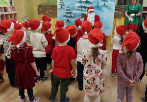 dzieci na stojąco śpiewają piosenkę dla Świętego Mikołaja