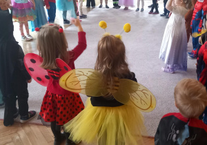 Przebrane dzieci w stroje karnawałowe tańczą w kole