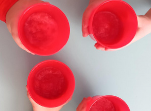 Dzieci pokazują kubki z sokiem