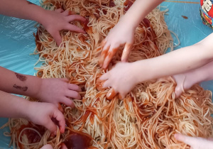 Dzieci bawią się kluskami z keczupem