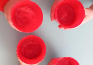 Dzieci pokazują kubki z sokiem