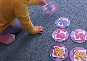 Dziewczynka dobiera w pary takie same dinozaury