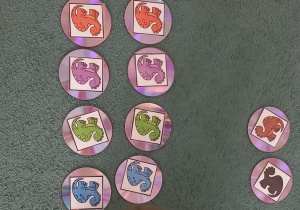 Dziewczynka dobiera w pary takie same dinozaury i układa je obok pozostałych