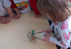 Dziewczynka wlewa ocet do słoika