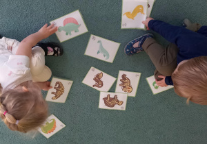 Dzieci dopasowują sylwetę dinozaurów do ilustracji przedstawiających ich szkielet