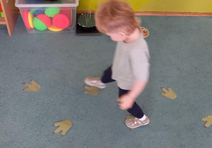 Chłopiec chodzi po śladach dinozaura