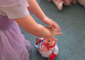 Dziewczynka naciska zabawkową świnkę