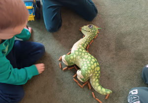 wybrane dzieci układają makaronowe kontury dinozaura