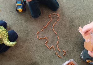 dzieci patrzą na powstałego „makaronozaura”