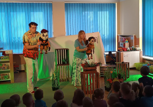 Aktorzy pokazują dzieciom lalki głównych bohaterów przedstawienia