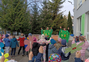 Dzieci tańczą trzymając w ręku papierowe kwiaty