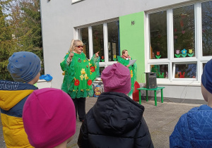 Dzieci z uwagą słuchają pani, która prowadzi koncert