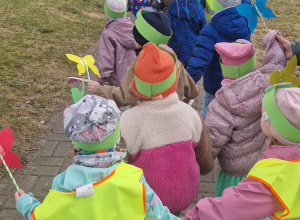 Dzieci idą w parach trzymając się za ręce.